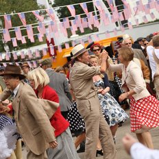 Goodwood Revival Besucher beim Tanzen in zeitgenössischer Kleidung