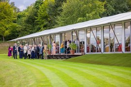 Opernbesucher in festlicher Kleidung vor den Marquees im Garten
